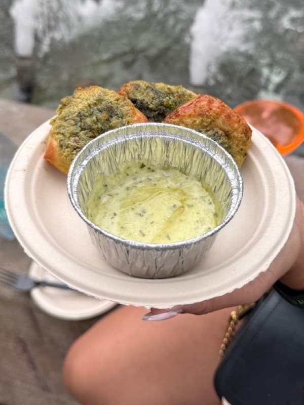 A festival plate at EPCOT with savory baked bites and a creamy herb dip